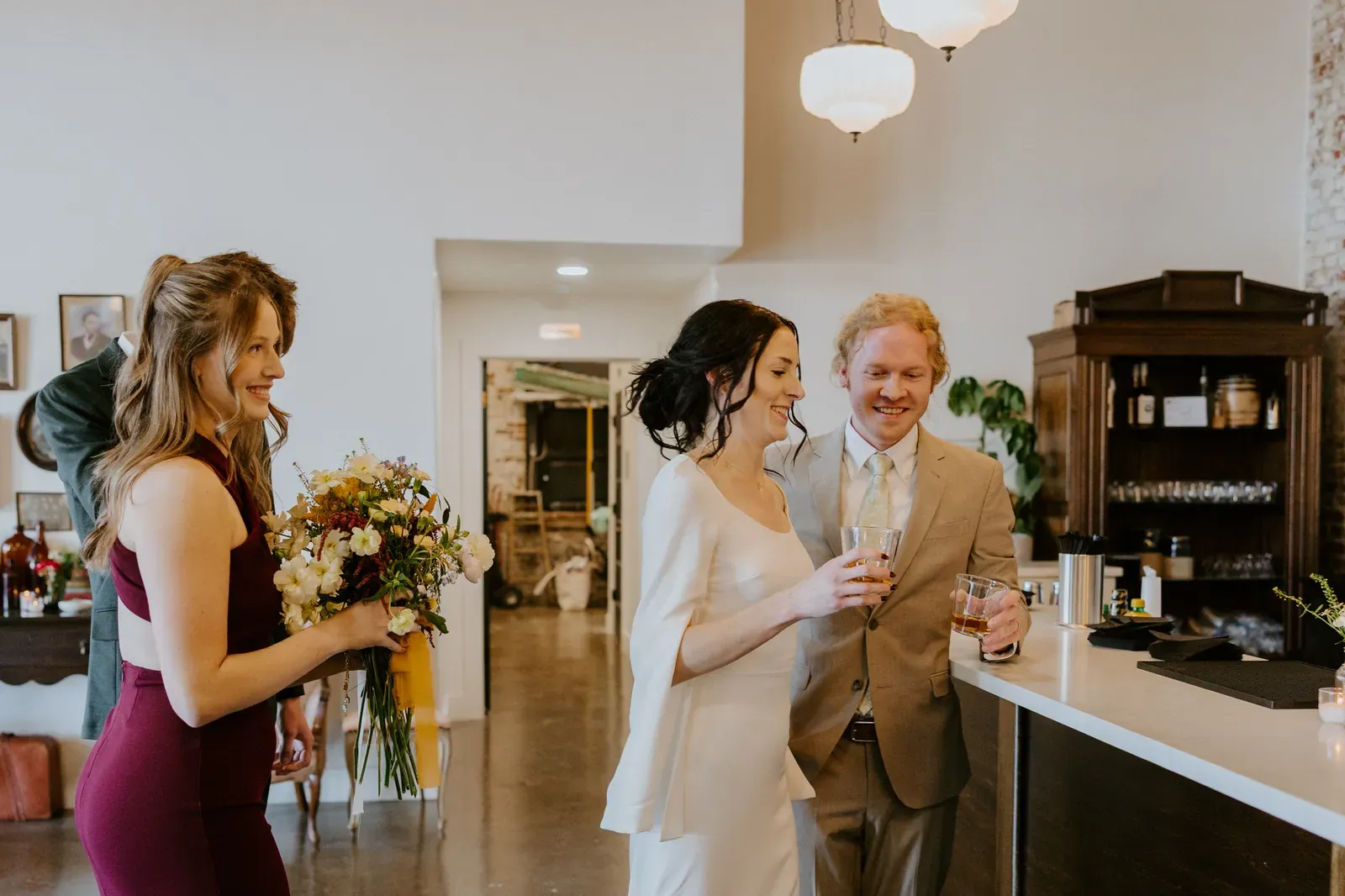 Wedding guests gathered at 24 Shelby's bar during an Indianapolis wedding reception with exposed brick and warm lighting