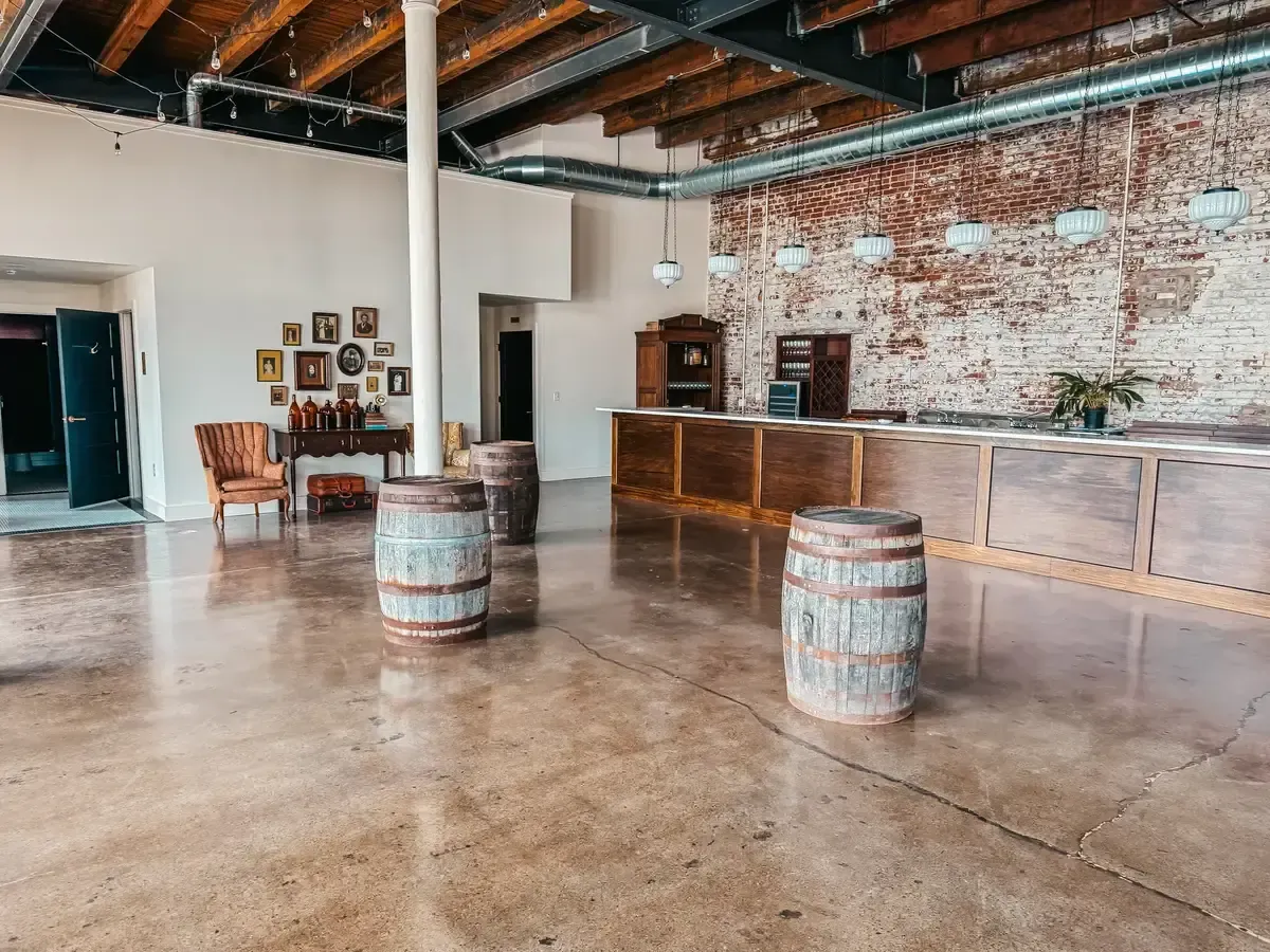 The Libations Lounge bar at 24 Shelby in downtown Indianapolis with original brick and warm lighting, the kind of room couples should see in person on a venue tour