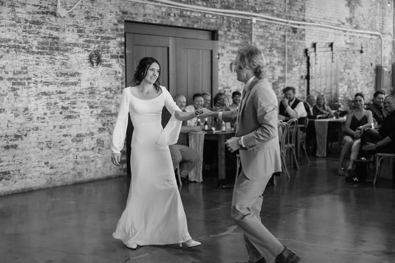Couple's first dance under Edison string lights at 24 Shelby, a downtown Indianapolis wedding venue with setup and lighting included in the rental.