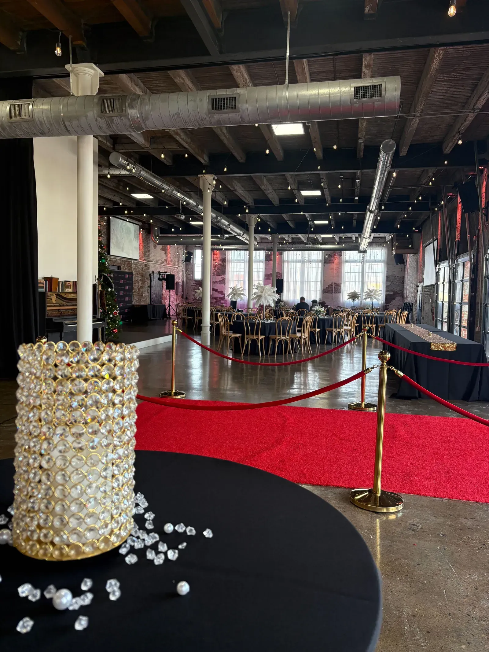A red-carpet product launch setup at 24 Shelby, a downtown Indianapolis corporate event venue, with stanchions, a gala centerpiece, and wall projection screens